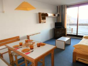 Una sala de estar con una mesa y un comedor. en Résidence Phenix - STUDIO CABINE 4/5 PERSONNES MAE-9844, en Le Corbier 9 fotos más