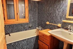 a bathroom with a sink and a bath tub at Chalet L'isard - Chalets pour 10 Personnes 534 in Peisey-Nancroix