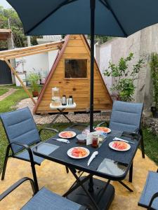 a table with plates of food and an umbrella at Hostel Gautamas Guest rooms in Tepoztlán