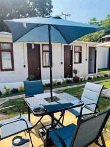 a table and chairs with a blue umbrella at Hostel Gautamas Guest rooms in Tepoztlán