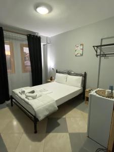a bedroom with a bed with white sheets and pillows at Alexandros apartments in Afitos