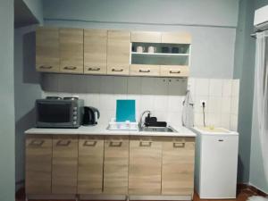 a kitchen with a sink and a microwave at Alexandros apartments in Afitos