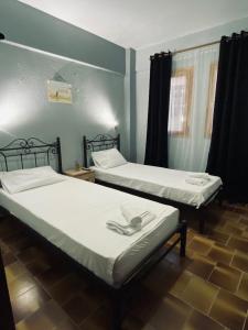 two beds in a room withthritisthritislictslictslictslicts at Alexandros apartments in Afitos
