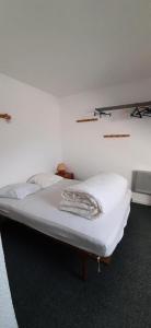 a bed in a room with a white wall at Résidence Les Tennis - 4 Pièces pour 8 Personnes 264 in Villard-de-Lans