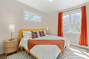 um quarto com uma cama com cortinas cor de laranja e uma janela em 3bd Contemporary in Raleigh: 5mins to Downtown em Raleigh