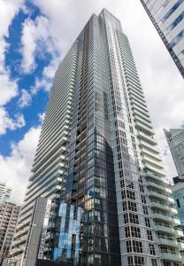 un edificio alto con ventanas de cristal en una ciudad en Luxurious Condo 1 King bedroom With Panoramic Views en Toronto