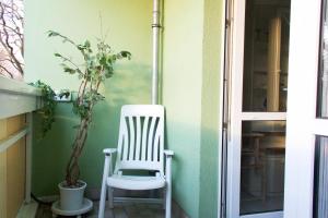 une chaise à bascule blanche assise sur une terrasse couverte dans l'établissement Home Wilma, à Berlin