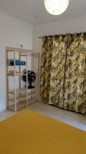 a room with a yellow rug and a curtain at Pousada Pitoresca in Mairiporã