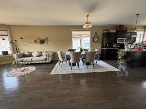 ein Wohnzimmer mit einem Sofa, einem Tisch und Stühlen in der Unterkunft Happy House - Regina City in Regina