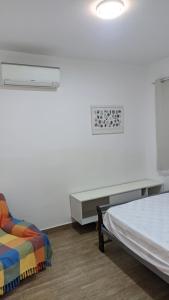 - une chambre avec un lit, un bureau et un canapé dans l'établissement Charmoso e confortável com A/C, à Pindamonhangaba