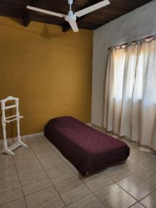 een bed in een kamer met een plafondventilator en een raam bij La Vivi in Villa Larca