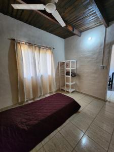 een slaapkamer met een bed en een plafondventilator bij La Vivi in Villa Larca