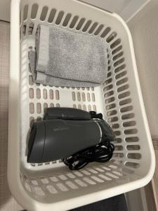 a white laundry basket with a black item in it at WORLD ASAHI HOTEL in Kawaguchi