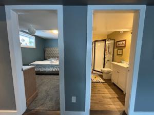a bathroom with a toilet and a bedroom with a bed at Happy House - Regina City in Regina