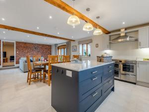 a kitchen with blue cabinets and a dining room at Nupton Hop Kiln in Kings Pyon