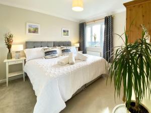 1 dormitorio con cama blanca y maceta en Pilots Rest, en Acklington