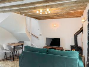 a living room with a couch and a tv at Jasmine Cottage in Elton