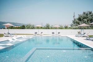 a swimming pool with chairs and umbrellas at Apartments Antique in Ulcinj