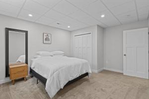 a white bedroom with a bed and a night stand at Dells Domain in Wisconsin Dells