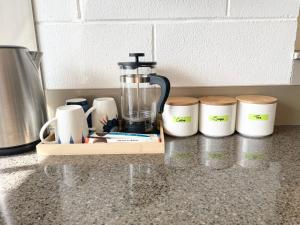 a blender on a counter next to four cups at Your home at Cockle Bay in Auckland