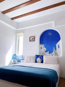 1 dormitorio con 1 cama grande y cabecero azul en Greek Frontier Villa, en Magong