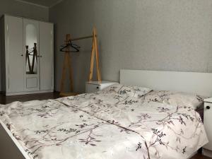 a bedroom with a bed with a white comforter at Уютные апартаменты рядом с Ситицентром in Uralsk