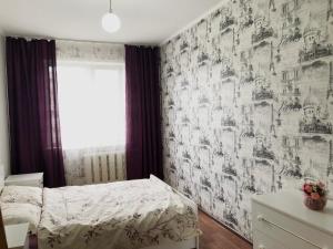 a bedroom with a bed and a wall mural at Уютные апартаменты рядом с Ситицентром in Uralsk