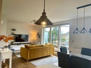 a living room with a yellow couch and a table at London Southgate 2bed Apartment in London