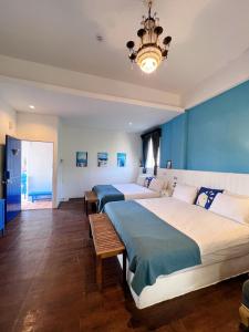 2 Betten in einem Schlafzimmer mit blauen Wänden und einem Kronleuchter in der Unterkunft Greek Frontier Villa in Magong