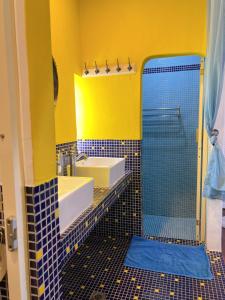 a yellow bathroom with two sinks and a shower at Greek Frontier Villa in Magong