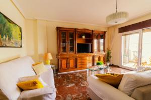 a living room with a couch and a tv at Villa Taala con terraza in Los Nietos