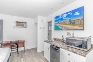 a kitchen with a counter with a tv on the wall at Sun Fun in Myrtle Beach