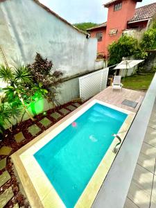 a swimming pool in the backyard of a house at Praia de Geribá e piscina para sua família! in Búzios