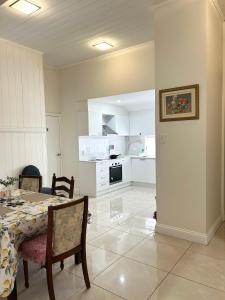 a dining room with a table and a kitchen at 26 Gladstone Rd Highgate Hill in Brisbane