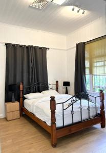 a bedroom with a large bed with black curtains at 26 Gladstone Rd Highgate Hill in Brisbane