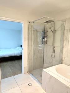 a bathroom with a glass shower with a tub at 26 Gladstone Rd Highgate Hill in Brisbane