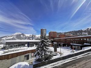 a snow covered city with a christmas tree and buildings at Résidence Sikkim - Studio pour 2 Personnes 764 in Aime-La Plagne