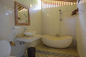 a bathroom with a large tub and a sink at Bali Natha Beach Front in Canggu