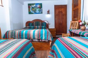 1 dormitorio con 2 camas individuales y puerta de madera en Hostal Cultural Bertha Challapampa Isla del Sol parte Norte, en Comunidad Challapampa
