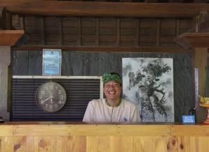a man standing behind a counter with a clock at Bali Natha Beach Front in Canggu