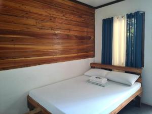 Un pat sau paturi într-o cameră la NoBi's Inn, Port Barton