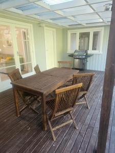una mesa de madera y sillas en una terraza en Holden's Hideaway MBT, en Rotorua