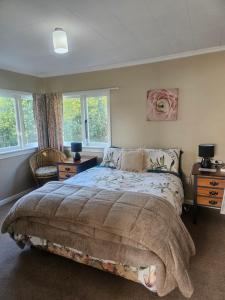 a bedroom with a bed and two windows at Holden's Hideaway MBT in Rotorua