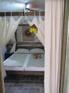 een slaapkamer met een bed met gordijnen en speelgoed erop bij Große Wohnung in Betina mit Whirlpool und Terrasse in Betina