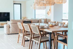 uma sala de jantar com uma mesa e cadeiras e um sofá em Villa Sal Marina Deluxe Lajares em Lajares