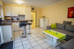 eine Küche und ein Wohnzimmer mit einem Sofa und einem Tisch in der Unterkunft Wohnung in Reckenfeld mit Eigener Terrasse in Greven