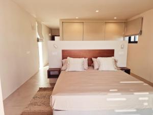a bedroom with a large white bed with two pillows at Villa Sal Marina Deluxe Lajares in Lajares