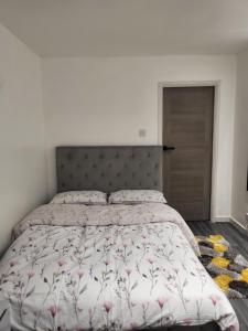 a bedroom with a large bed with a floral bedspread at Fuzzys place in London