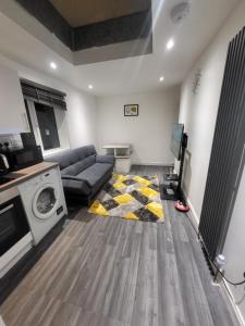 uma sala de estar com um sofá e uma máquina de lavar roupa em Fuzzys place em Londres
