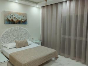 ein Schlafzimmer mit einem Bett und einem Wandgemälde in der Unterkunft Maison tnazefti in Djerba